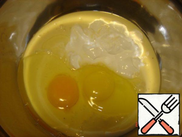 Beat the eggs with sour cream and condensed milk.
