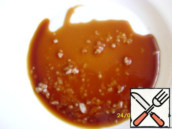Squeeze garlic and mix with soy sauce.