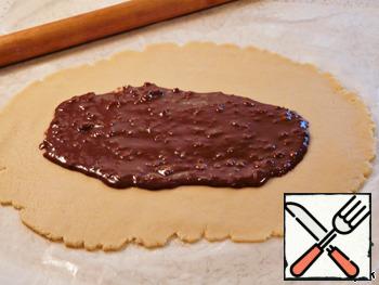 Preheat oven to 180 degrees. Oil the baking paper and place it on a large baking sheet.
Remove the first portion of the dough from the refrigerator. Roll the dough into a rectangle on the floured parchment.
part of the chocolate filling spread in the middle of the rectangle.
