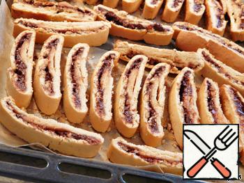 Cut them diagonally, you can directly on the baking sheet.
Don't worry if the biscotti starts to crumble slightly when you slice them, use the sharpest and longest knife in the house if possible.
Very gently flip the biscotti.