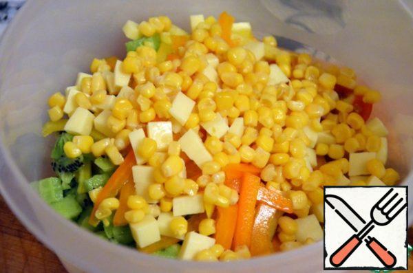 In the salad bowl spread kiwi, pepper, cheese, tomatoes, corn (pre-drain the liquid), pour the top dressing, sprinkle with sesame seeds.