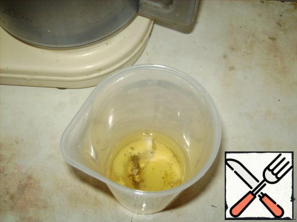 Put an egg in a whipping bowl, sprinkle with spices, pour vegetable oil.
