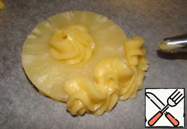 From the same pastry syringe continue to squeeze the dough on the edge of the pineapple wave-like movements. Connecting the base and sides (This is very important, should be United like a basket).. And squeeze some dough into the middle.
