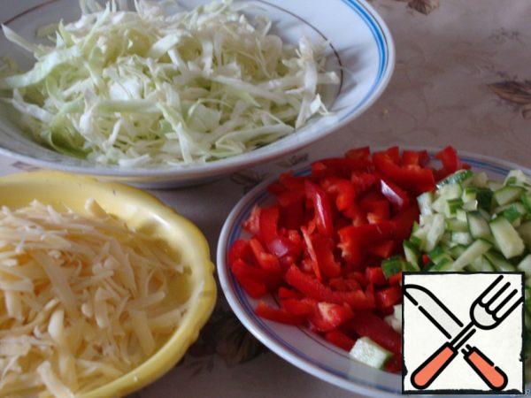 Chop cabbage, cucumbers and peppers into strips.
Walnuts grind not very finely.
Cheese to grate on a large grater.