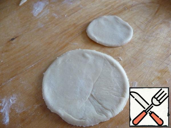 Roll out the dough into a layer 3 mm thick and cut out an equal number of circles with a diameter of 12 and 9 cm.