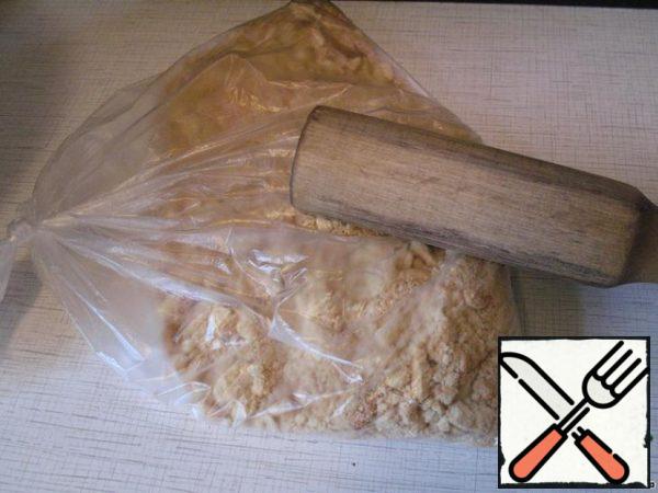 Cookies put in a plastic bag, tie it. Roll the bag with a rolling pin to crumble cookies (but not in small crumbs!).