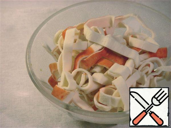 Expand crab sticks, cut into thin strips. Now send it to the microwave and heat it well. They should be hot.
