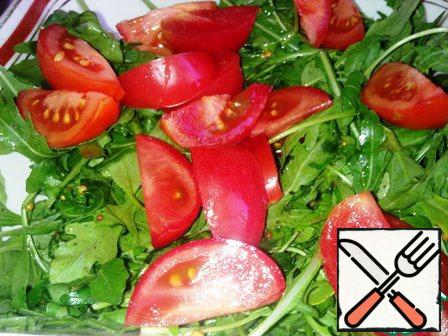 Cut the tomato into small slices. Add to arugula and mix.
