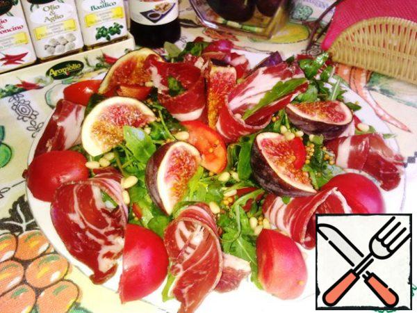 Transfer the salad to a flat dish, make ham rolls, spread around the edge of the entire plate and steamed in the center, then lay out the figs and lightly sprinkle with soy sauce. Sprinkle with pine nuts.