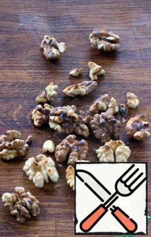 While the beans are cooking, fry the peeled nuts in a dry pan. You can, of course, not to do this, but I love the taste of roasted nuts. Nuts cut with a knife or break into pieces, leave a few halves intact for decoration.