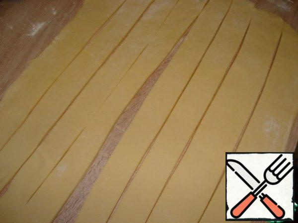 Cut the sheet lengthwise into 8 strips 30 cm long . Pull out strips up to 40-60 cm long, twist in a spiral around its axis, then roll into a roll.

