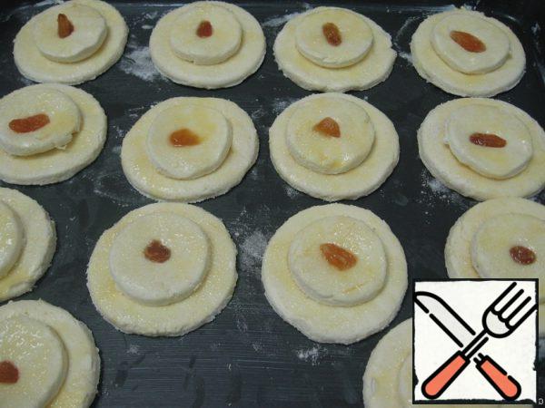 Put the small cakes on the big ones, twist the top, press it with your finger.
Place the cheesecakes on a baking sheet greased with margarine. Refrigerate for 20 minutes.
