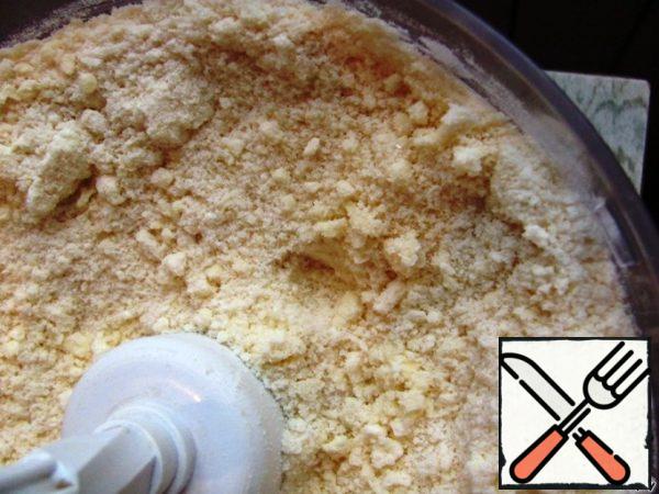 Sift the flour in a pile on a cutting Board together with the baking powder and vanilla, sprinkle the top 2/3 of the stack. sugar and put 300 g of chilled butter, cut into pieces. Chop with a knife until crumbs. You can do this with a food processor.