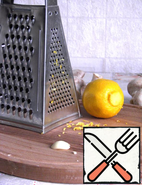 Grate the zest of a lemon - about 1 tbsp. Squeeze 1 tbsp of lemon juice. Chop the garlic clove.