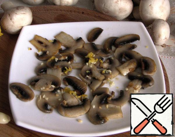 Sprinkle the fried mushrooms with zest and garlic, pour lemon juice.
