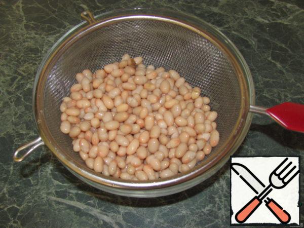 Beans fold in a colander, rinse in cold water and leave for 5-10 minutes.
