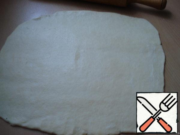 Roll out the dough into a thin layer, the length of which corresponds to the length of the baking dish (form for English cake).