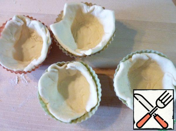 Defrost the puff pastry, roll it out slightly, cut it into squares and put it in cupcake molds (I have silicone ones).
Grate the lime zest on a grater and squeeze the juice out of it.

