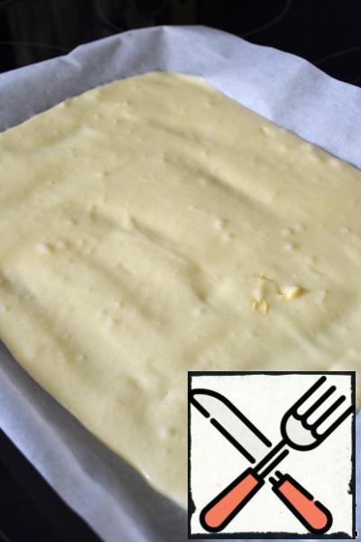 Lay a small baking sheet with baking paper. Size-about 25x35 cm. Pour the dough, level with a spatula.