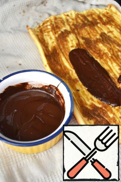 Melted chocolate. Spread it over the inner layer of the sponge cake.
