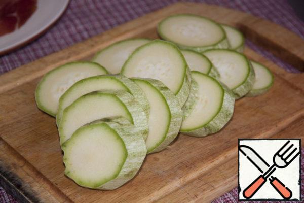 The second component is zucchini. I love the taste of it, cooked over an open fire or charcoal. Take a whole zucchini and cut into place rings.