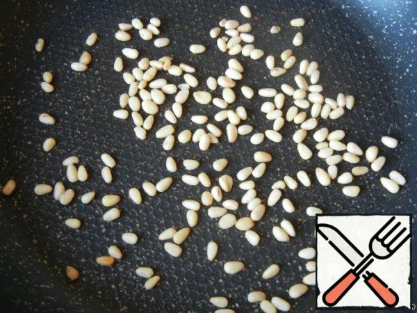 Fry pine nuts in a well-heated frying pan without oil.
