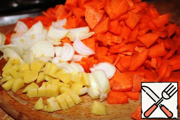 Carrots clean and cut into triangles. Onions clean, cut into half rings. Peel the ginger, finely chop.