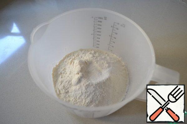 First, in a container mix 200 g flour, salt and baking powder.