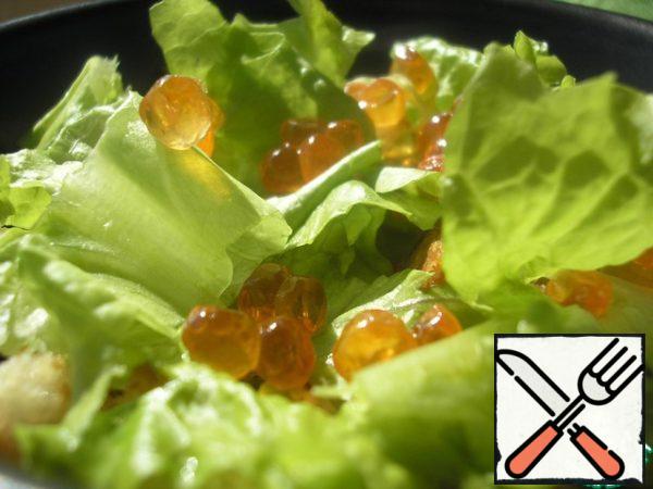 On the chicken put 1 tsp eggs, then crackers.
Lettuce tear into small pieces and spread in salad bowls.Decorate with 1 tsp caviar.