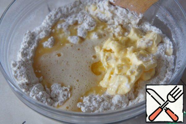 Then mix the flour with yeast with a wooden spoon, pour in the eggs beaten with sugar and salt, add butter and knead the dough.
