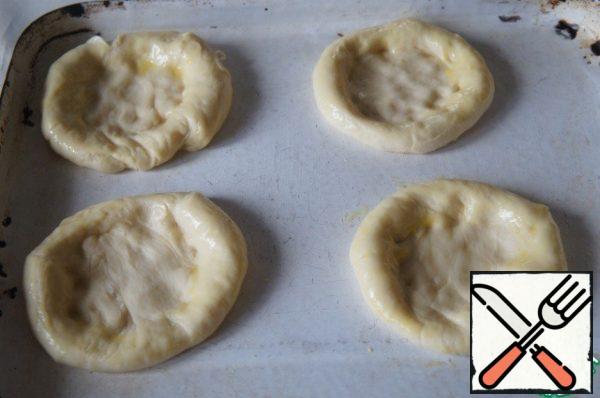 Molded cakes with raised edges, put them on a baking sheet and brush with beaten with 1 tsp water and egg yolk.