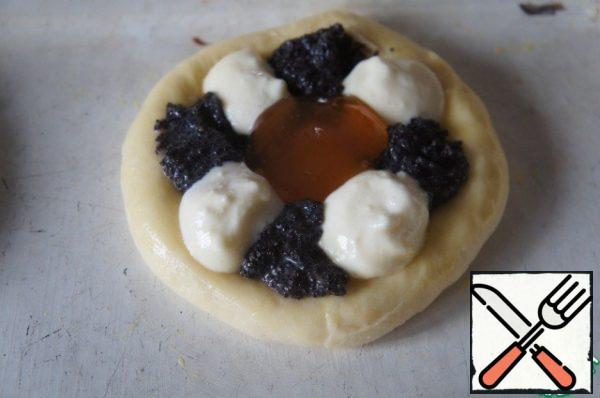 Place the curd-poppy filling in the middle with a teaspoon in a staggered order, and put the jam in the center.
