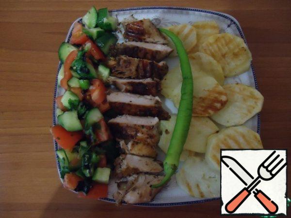 It took an hour, put the Breasts on a heated grill. The dish is ready, served with potatoes on the grill. Decorate with tomatoes, cucumbers and pepper.