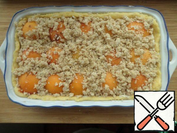 Streusel preparation. Grind 4 tbsp. oatmeal flecks, add butter, sugar and cinnamon, grind into crumbs and sprinkle with apricots.