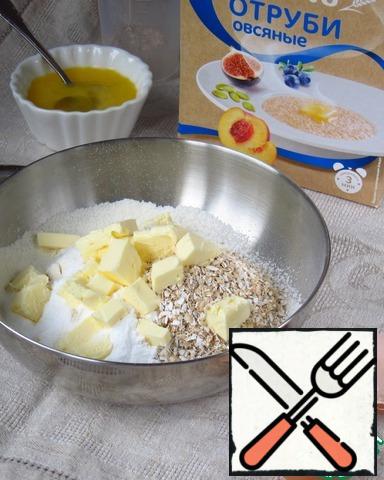 The recipe from the magazine is taken as a basis.
In a bowl sift a Cup of flour (just keep for dressing), 1 tablespoon powdered sugar (more, to taste), add a pinch of salt, oat bran, and cold butter, diced. Chop with a knife (or grind with a fork) into crumbs.