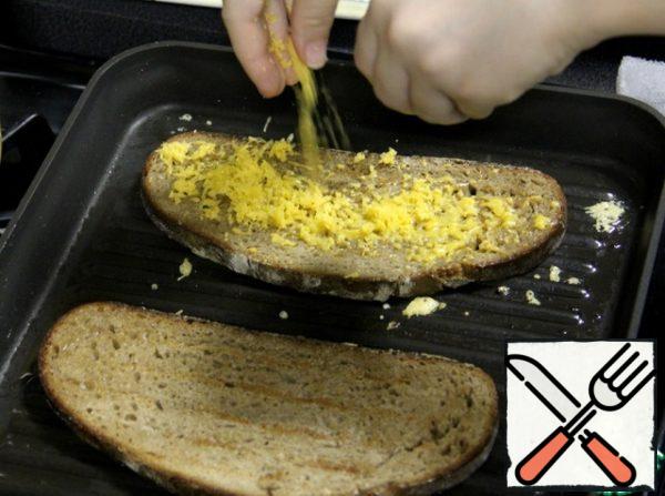 Cheese rub on a fine grater and sprinkle one piece of bread.