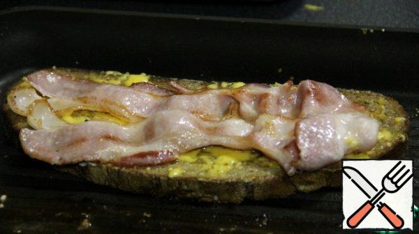 Put the bacon on top of the cheese.