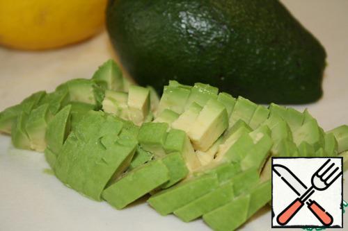 Cut the avocado lengthwise in half, then turn the halves in different directions and detach from the bone.
Peel and cut into small pieces.
Carefully pour the lemon juice, but lime is better.