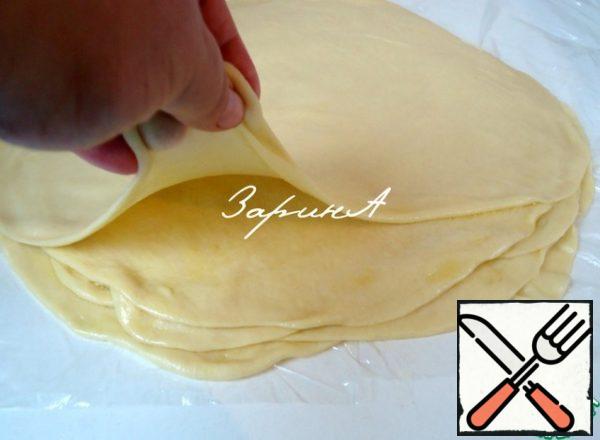 Each ball rolling pin roll out into a thin cake and grease with butter.