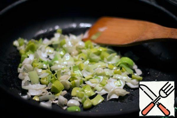 In a heated pan with olive oil, fry finely chopped leeks and garlic, until soft, stirring.