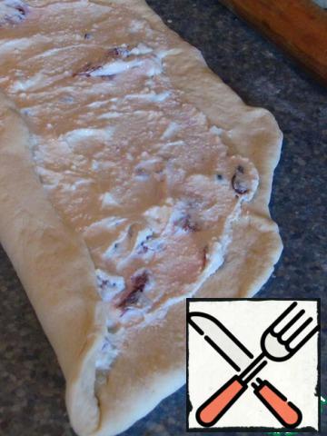 Distribute the filling and roll the dough.