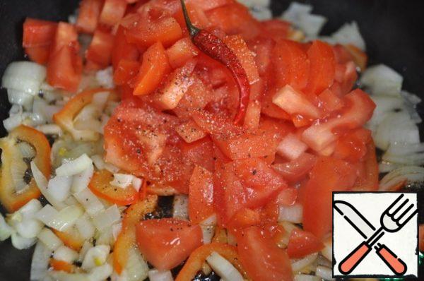 Put a piece of butter, finely chopped onion, garlic and bell pepper in a frying pan, fry for 2 minutes.
Add finely chopped tomatoes, red ground hot pepper, ground black pepper and salt. Mix everything and simmer for 10 minutes.