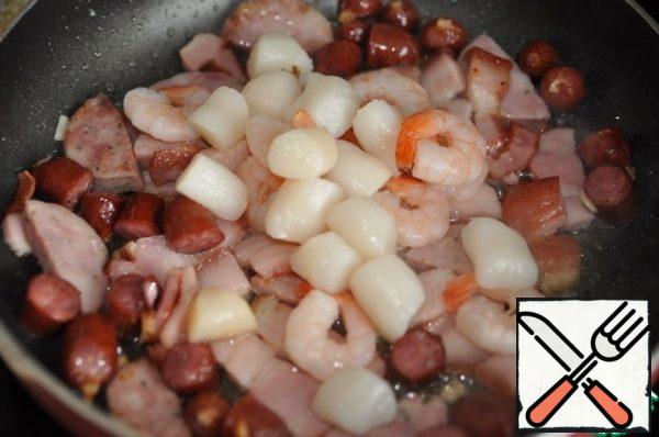 Fry meat products in vegetable oil in a frying pan until a crust forms.
Add seafood to them. Don't be afraid of a combination of meat and seafood.
I have boiled frozen shrimp and frozen scallop (all pre-thawed and peeled).