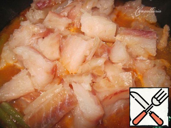Then add the pieces of white fish and fry over medium heat with the lid closed for 5-7 minutes.
