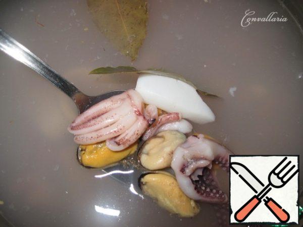 Boil water in a saucepan, add bay leaf and seafood, previously thawed and washed.
Bring to a boil, cook for 3 minutes.
