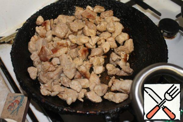 Pork cut into medium cubes (see 1.5), rub with salt and pepper and fry in oil over high heat until half cooked for 10 minutes.
