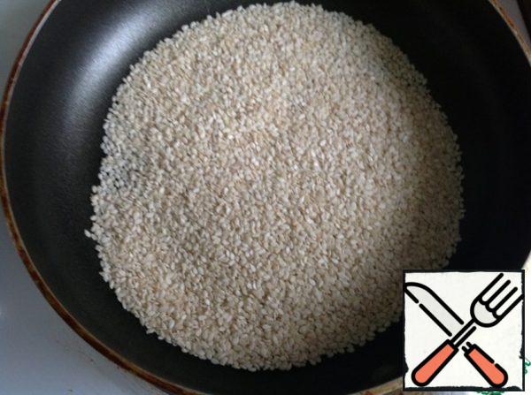 Fry the sesame seeds in a dry frying pan and add them to the salad bowl with the beans.
