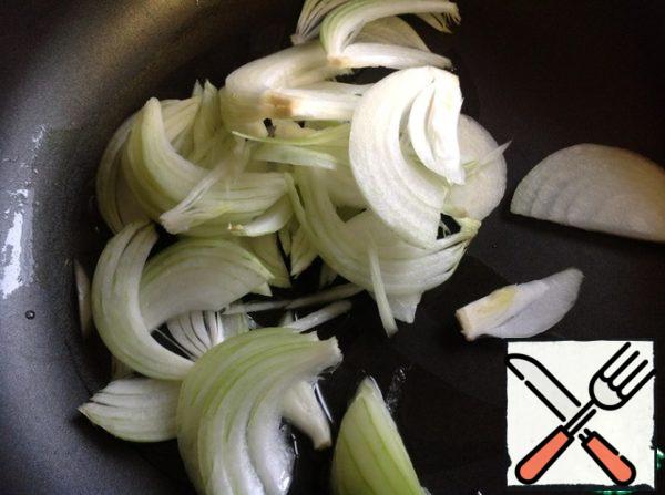 In a well-heated pan pour oil and put the onion, cut into half rings.