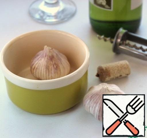 At the heads of garlic slightly trim the bottom, put in a small baking dish, pour a glass of wine, add sugar and put in a preheated 200 * oven for 15-20 minutes.
The recipe offered dry red wine, I used dry white.