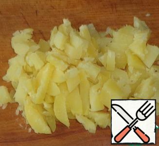 Peel boiled potatoes and cut into strips or cubes. In a separate bowl, salt potatoes to taste and pour vegetable oil. Stir with a spoon so that the oil is evenly distributed over the potatoes.